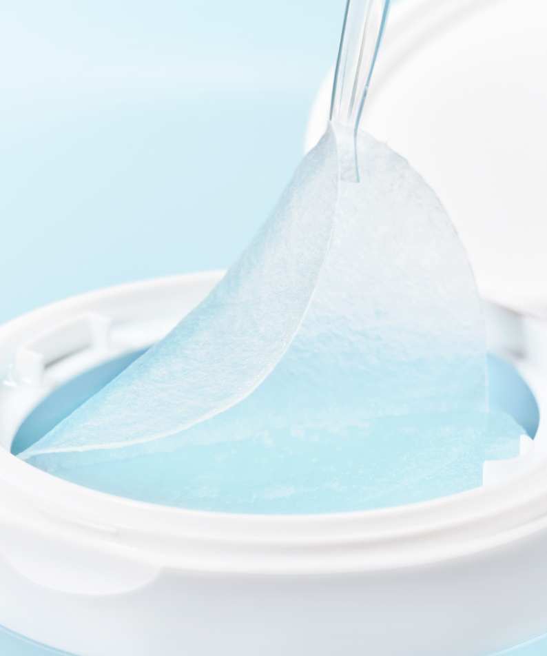 Close-up of SKIN1004 Madagascar Centella-Hyalu-Cica Jelly Fit Ampoule Pads (60 sheets) in a white container with a pad being removed.