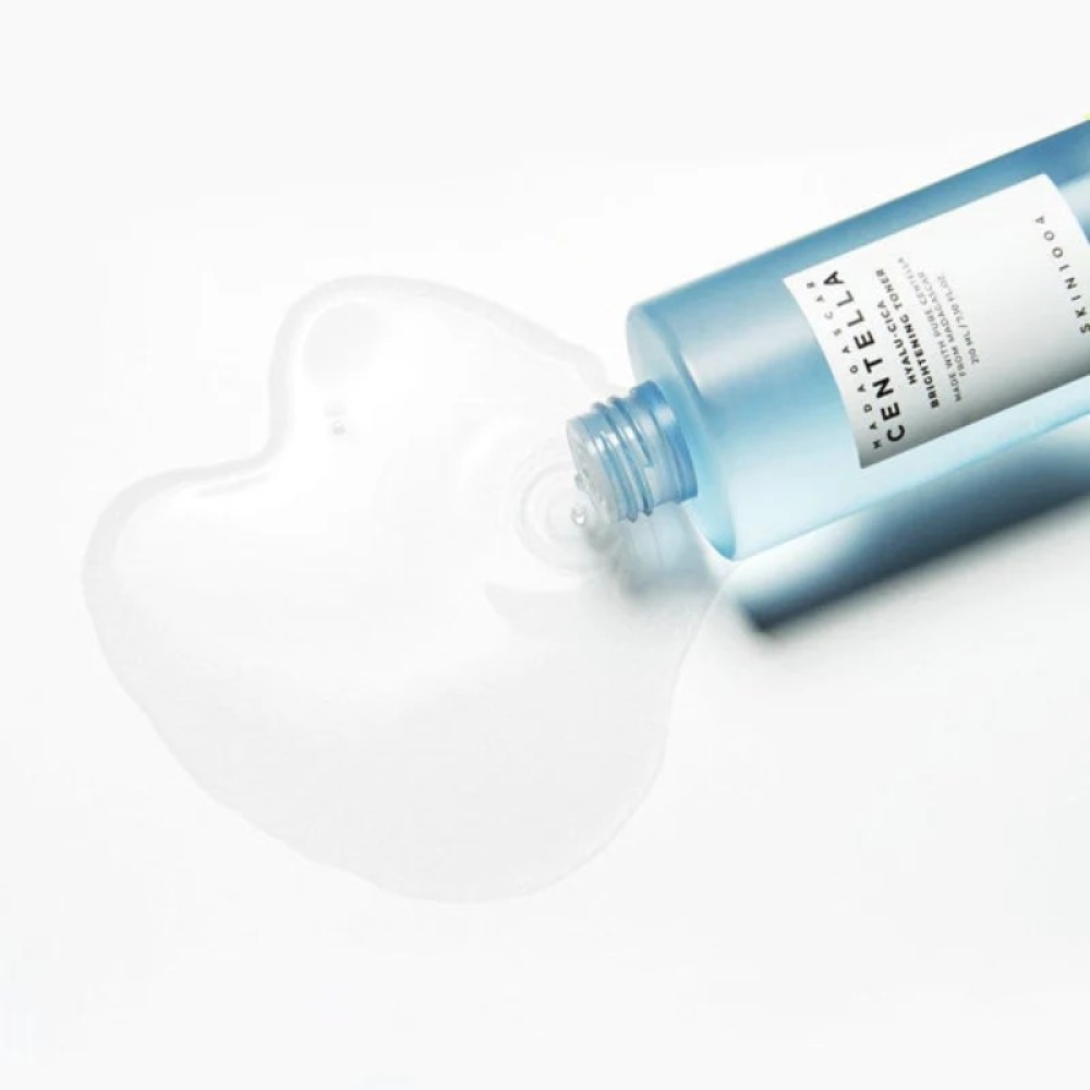 SKIN1004 Madagascar Centella Hyalu-Cica Radiance Toner 210ml bottle with spilled toner on white background.