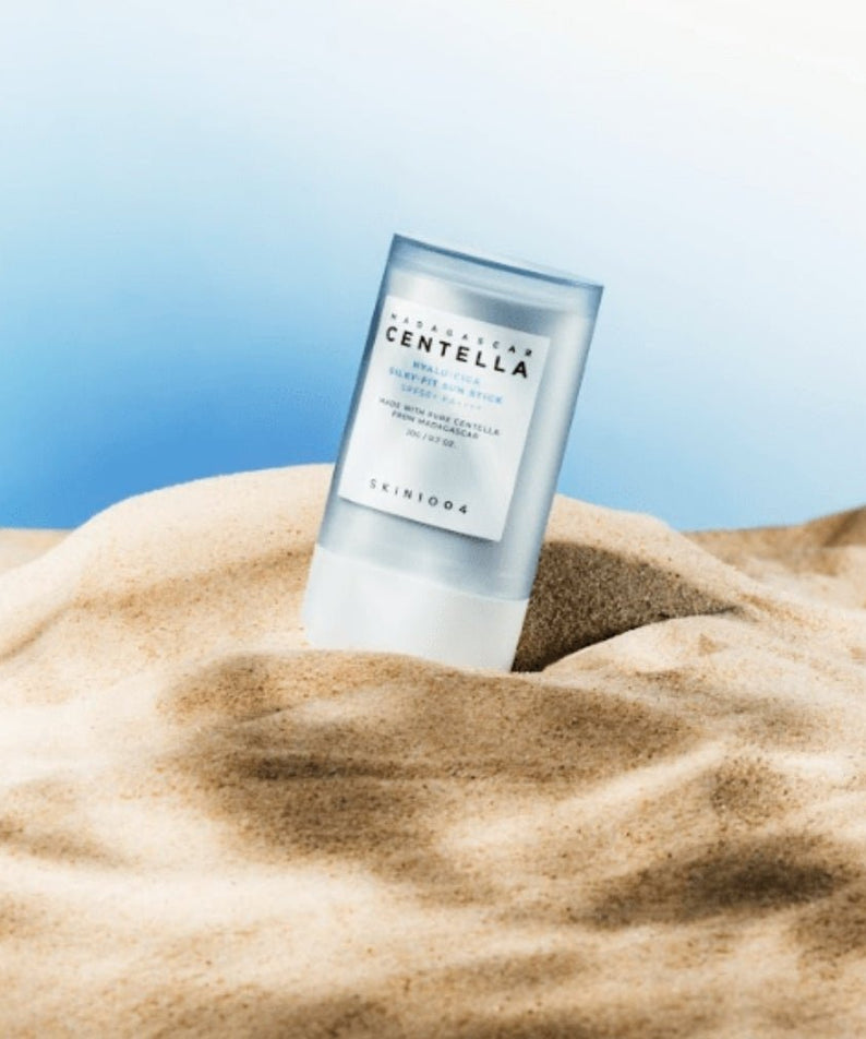 SKIN1004 Madagascar Centella Hyalu-Cica Silky Fit Sun Stick 20g on sand with blue sky background