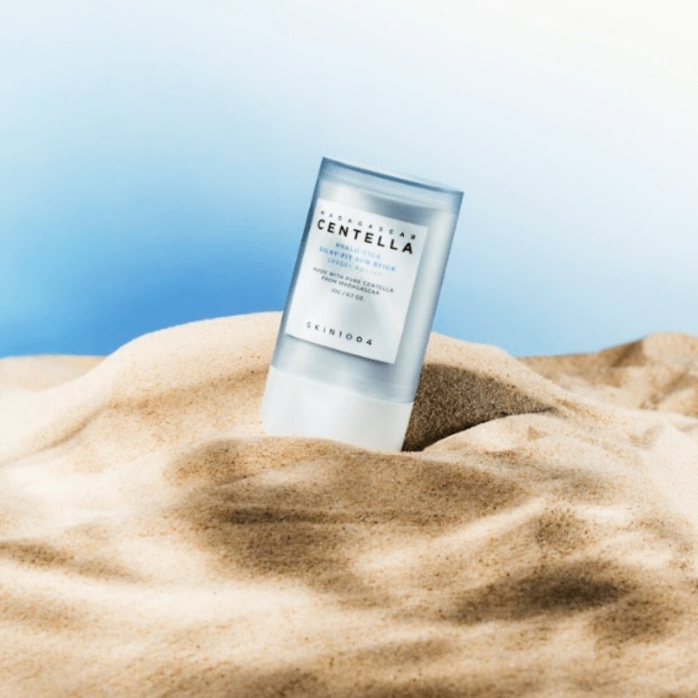 SKIN1004 Madagascar Centella Hyalu-Cica Silky Fit Sun Stick 20g on sand with blue sky background