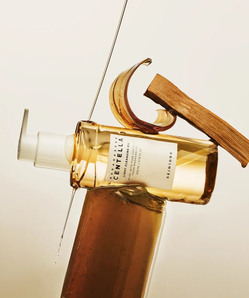 Bottle of SKIN1004 Madagascar Centella Light Cleansing Oil 200ml with elegant design display on neutral background.