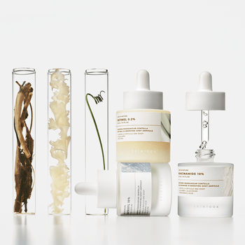 SKIN1004 Madagascar Centella Matrixyl 10 Boosting Shot Ampoule 30ml on display with natural ingredients in test tubes.