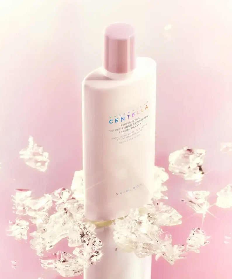 SKIN1004 Madagascar Centella Poreizing Velvet Finish Sunscreen 50ml in elegant packaging against a pink background with ice crystals.