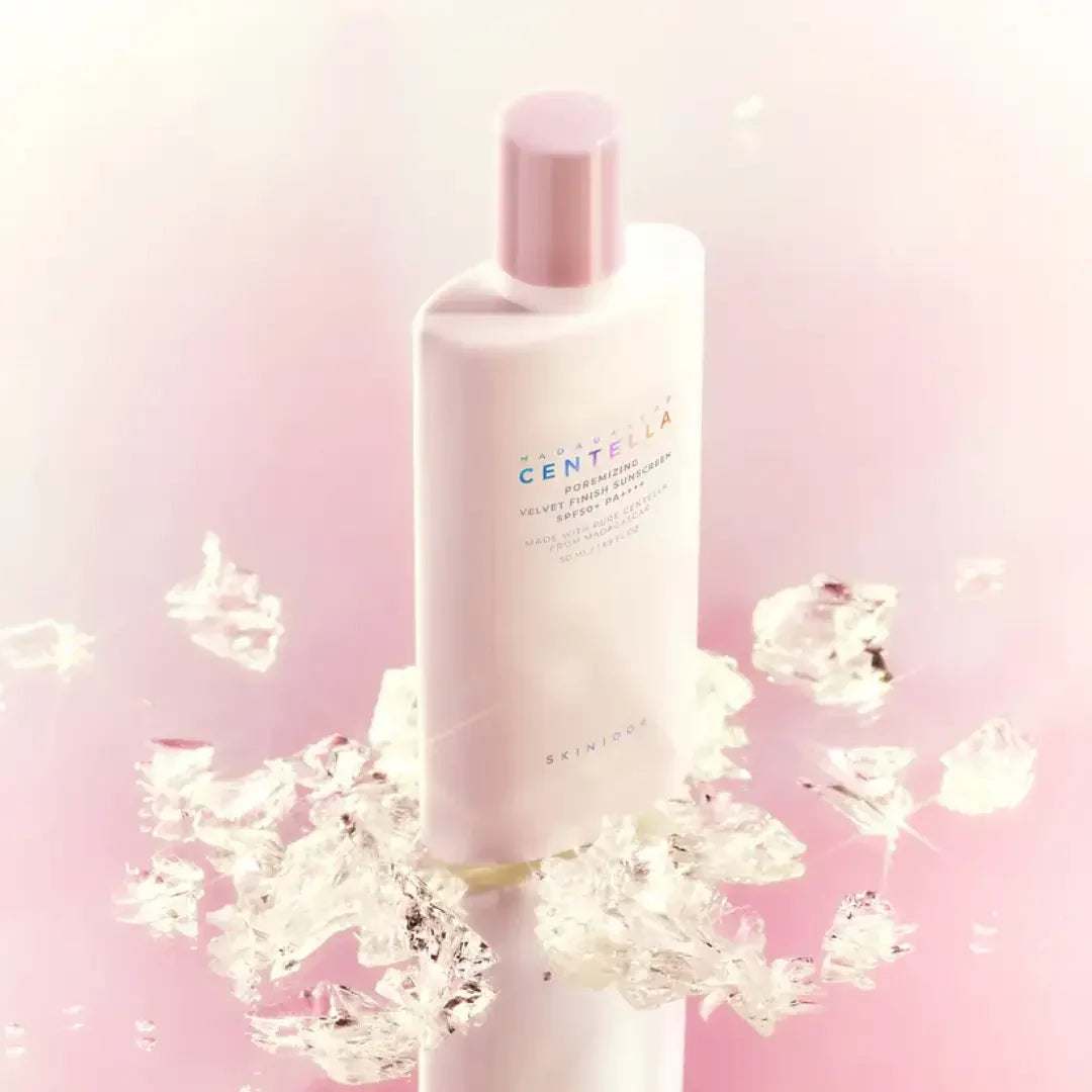 SKIN1004 Madagascar Centella Poreizing Velvet Finish Sunscreen 50ml in elegant packaging against a pink background with ice crystals.