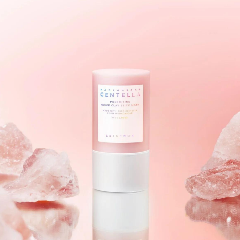 SKIN1004 Madagascar Centella Poremising Quick Clay Stick Mask 27g on a pink background with rose quartz crystals.