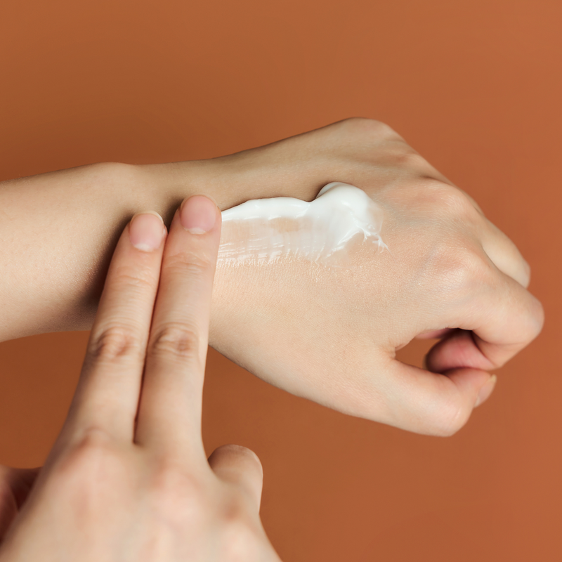 Person applying SKIN1004 Madagascar Centella Probio-cica Enrich Cream 50ml on hand for skincare.