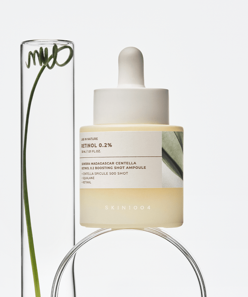 SKIN1004 Madagascar Centella Retinol 0.2 Boosting Shot Ampoule 30ml displayed beside a clear glass tube with a leaf.
