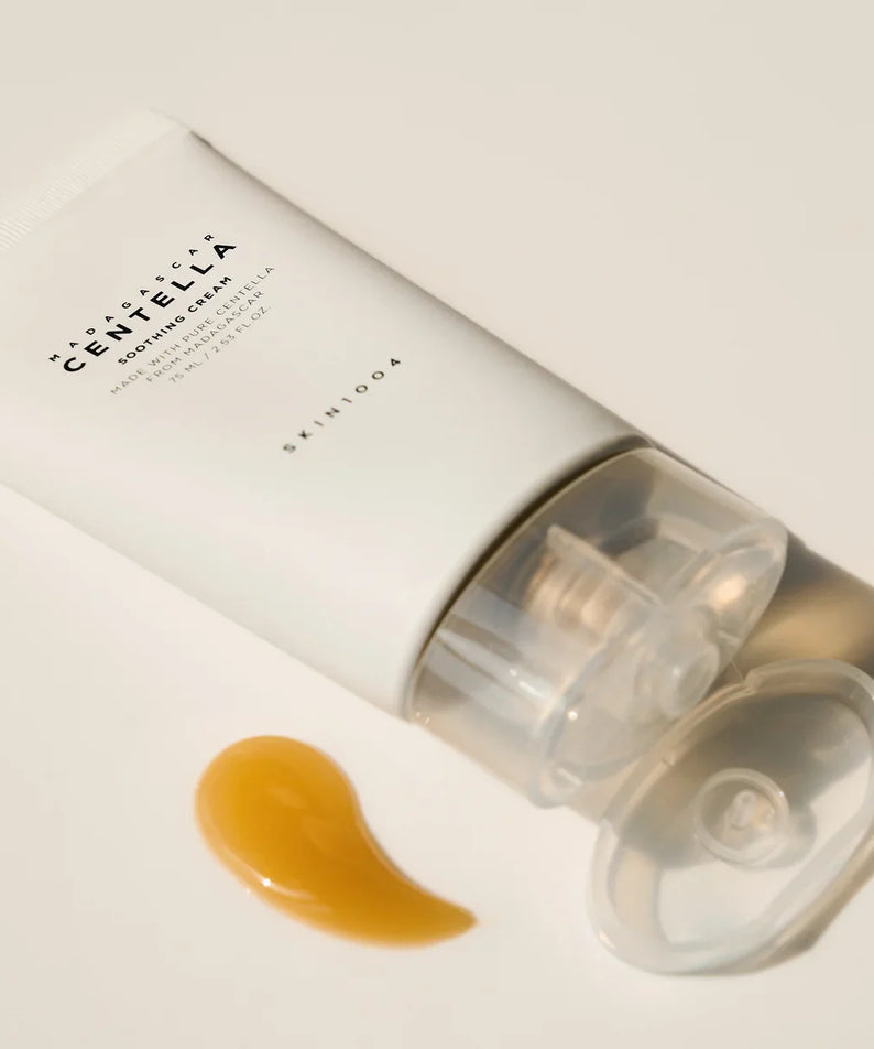 Tube of SKIN1004 Madagascar Centella Soothing Cream 75ml with cream sample next to it on a light background.