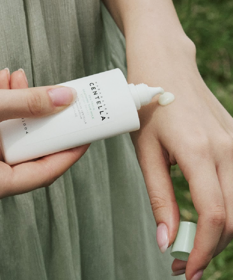 Applying SKIN1004 Madagascar Centella Tea-trica Soothing Sun Milk 50ml on skin outdoors