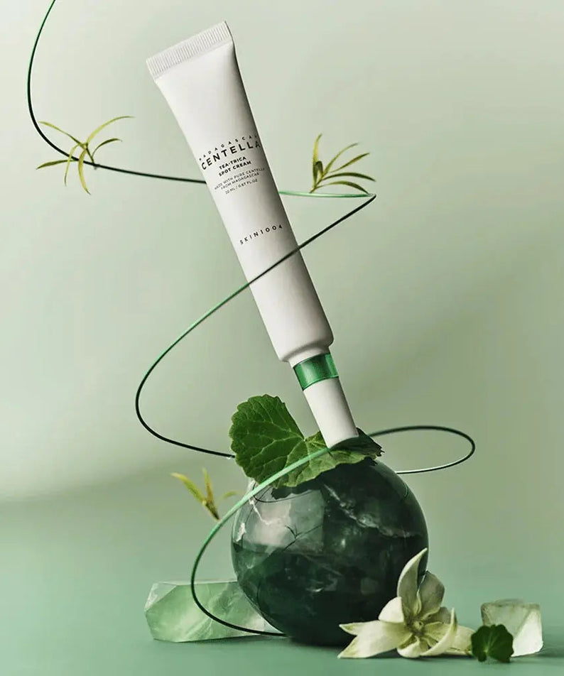 SKIN1004 Madagascar Centella Tea-trica Spot Cream 20ml displayed creatively with green and floral elements.