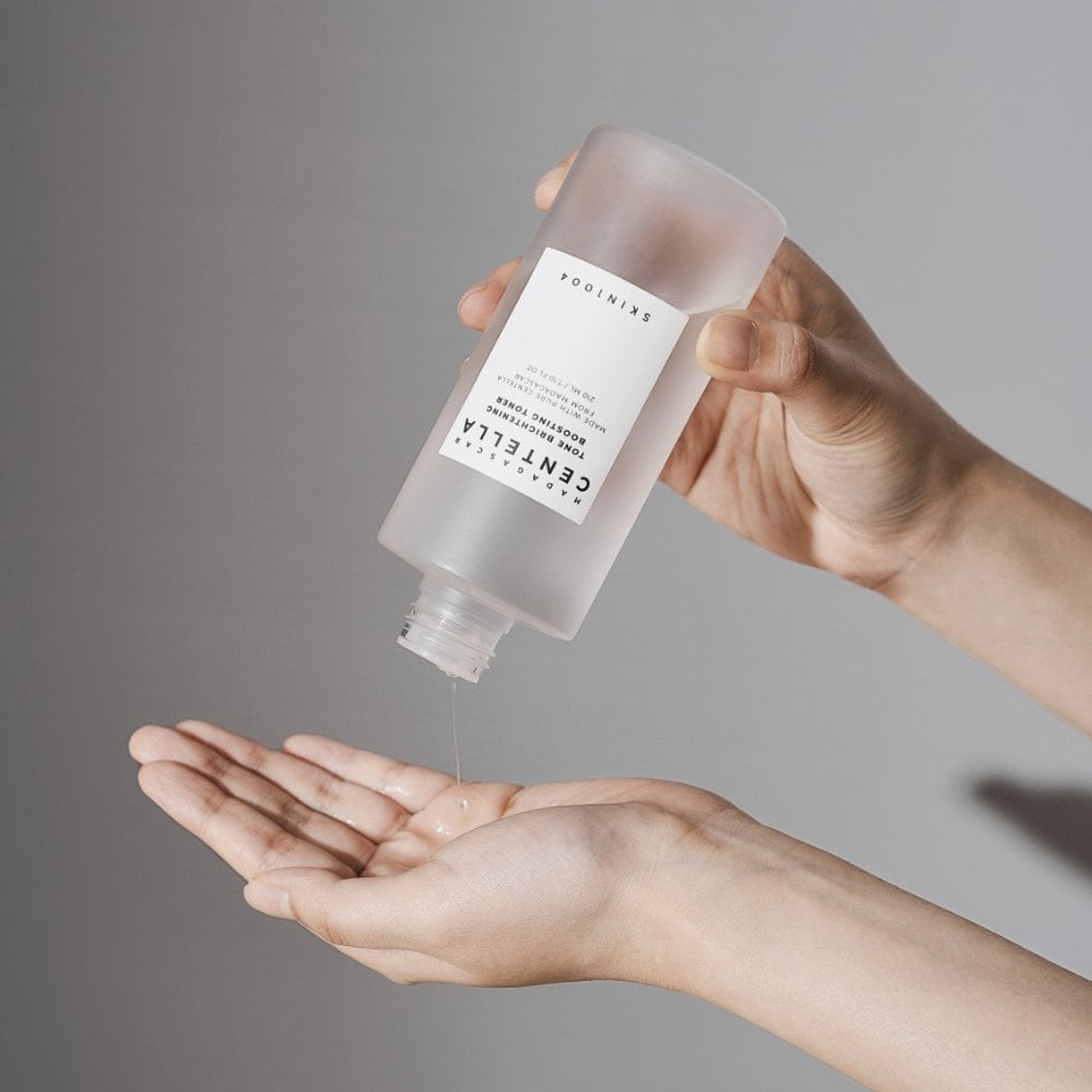 Applying SKIN1004 Madagascar Centella Tone Brightening Boosting Toner 210ml to hands