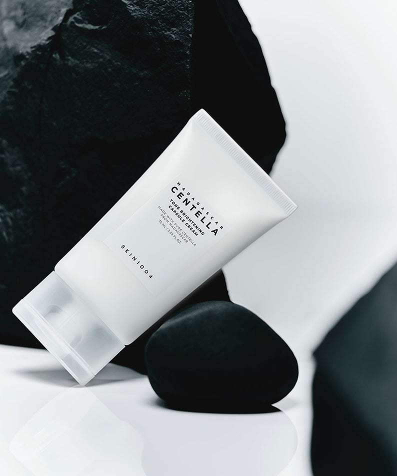 SKIN1004 Madagascar Centella Tone Brightening Capsule Cream 75ml product tube on a minimalist rock background.