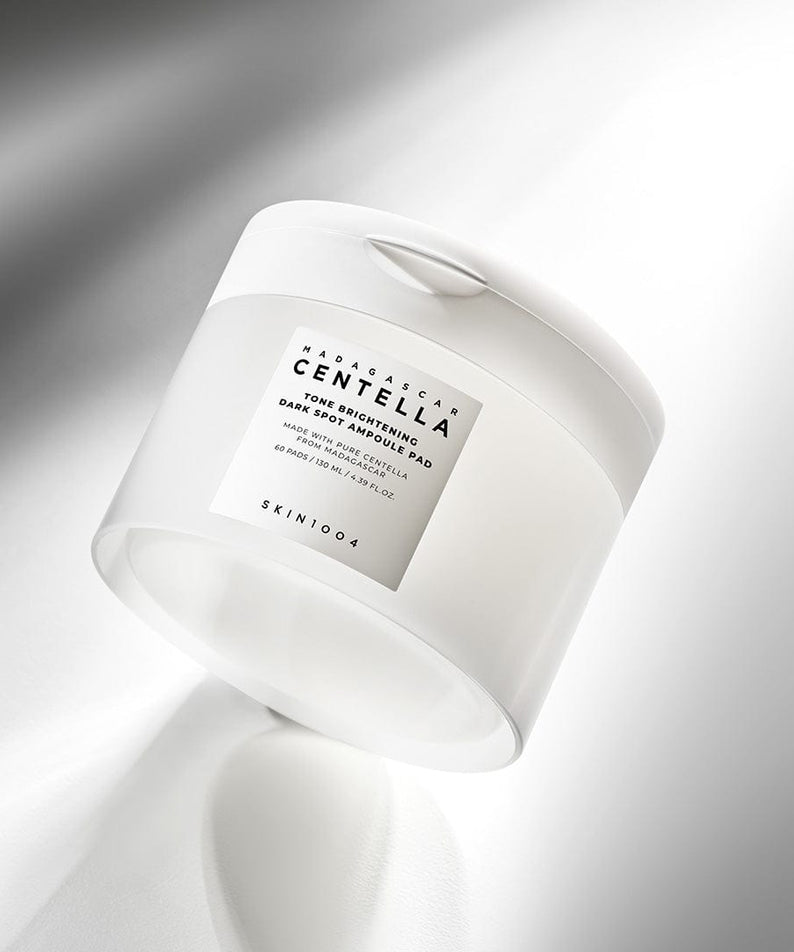 SKIN1004 Madagascar Centella Tone Brightening Dark Spot Ampoule Pads (60 sheets) in a sleek white container.