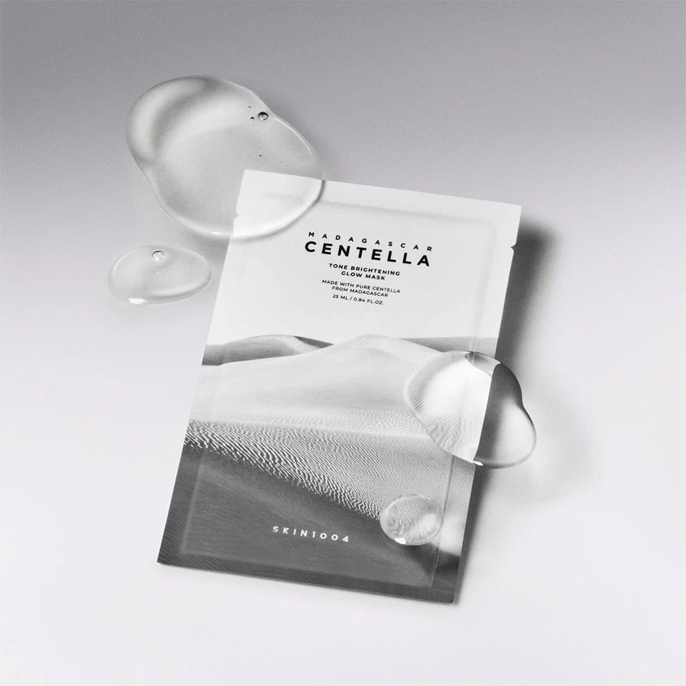 SKIN1004 Madagascar Centella Tone Brightening Glow Mask 25ml [5 sheets] on a sleek background with water droplets