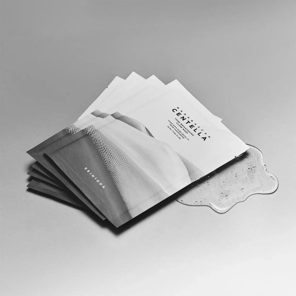 SKIN1004 Madagascar Centella Tone Brightening Glow Mask 25ml [5 sheets] displayed fanned out on a smooth surface.