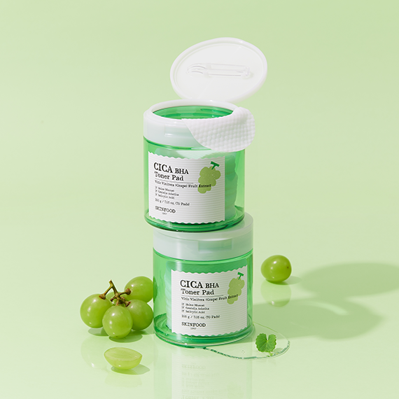 Two SKINFOOD CICA BHA Toner Pad containers with green grapes and mint leaves on a light green background.