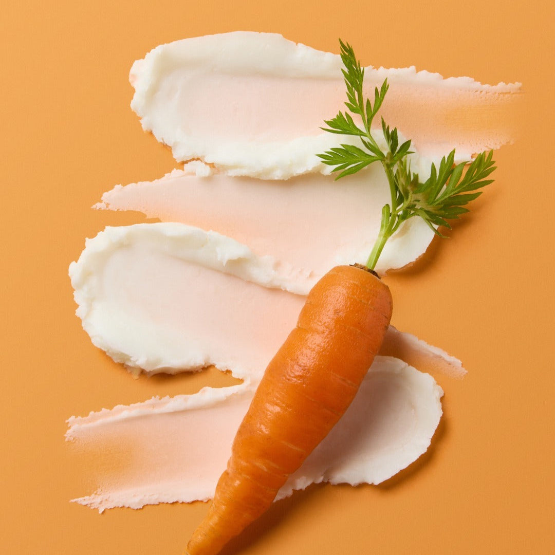 SKINFOOD Carrot Airy Soft Sun Stick 18.5g moisturizing cream with a fresh carrot on peach background