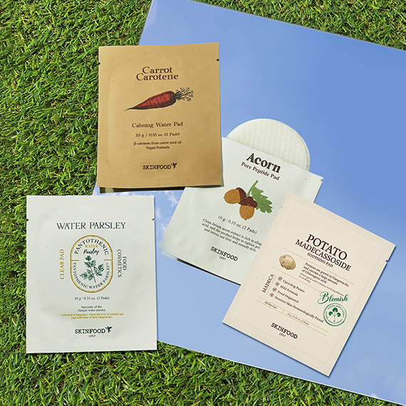 SKINFOOD Carrot & Potato & Acorn & Water Parsley Pad Kit displayed on grass and blue background.