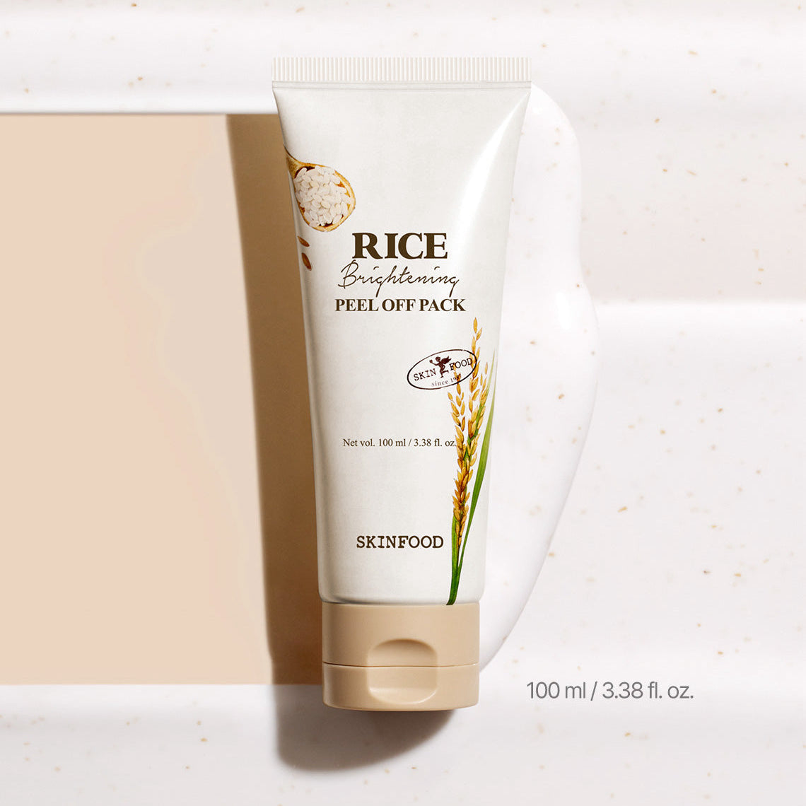 Image of SKINFOOD [NEW] Rice Brightening Peel-Off Pack 100ml with cream smear on white surface.