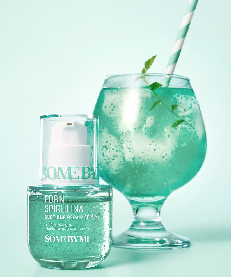 SOME BY MI PDRN Spirulina Soothing Repair Serum 50ml displayed with a green drink in the background.
