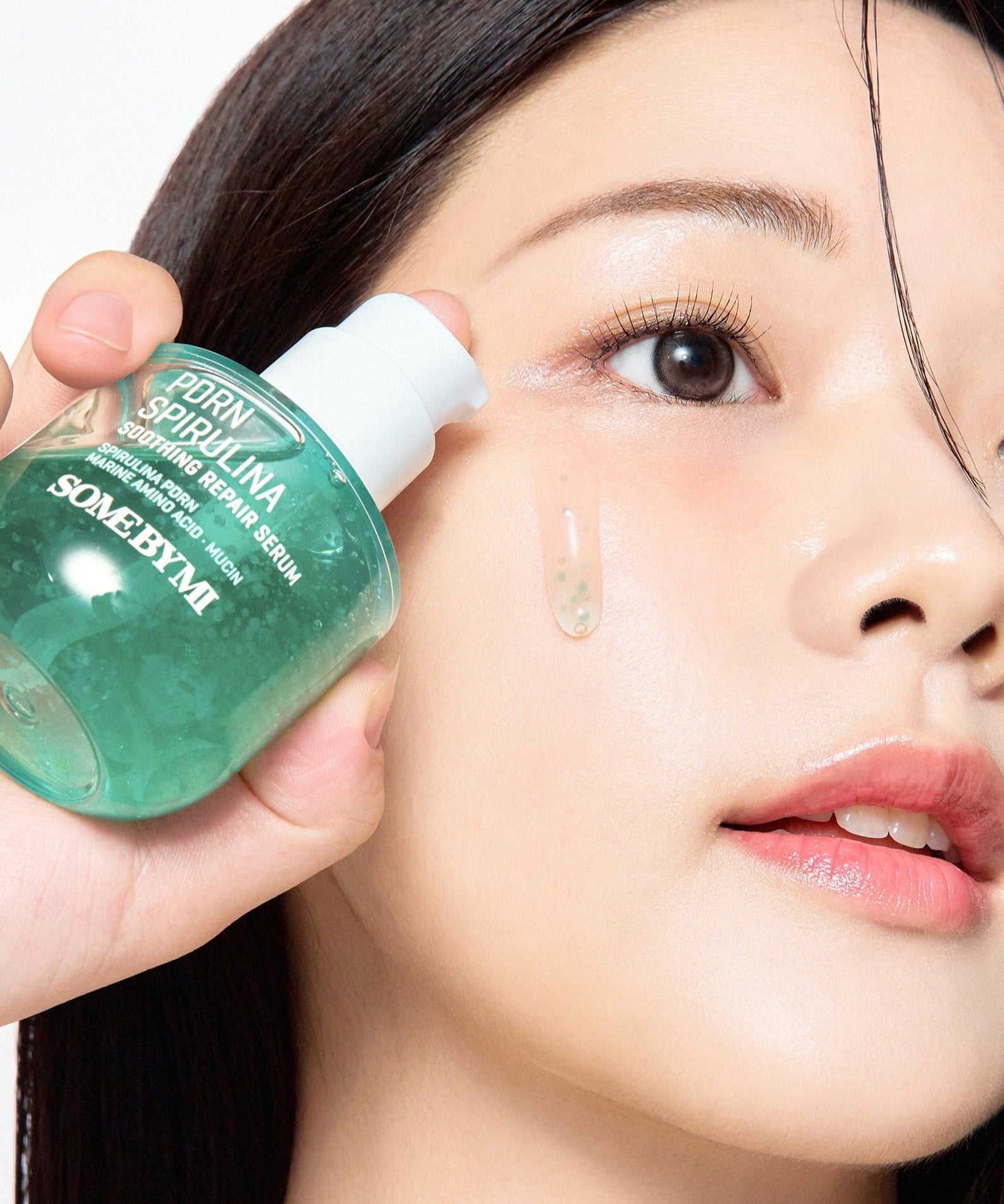 Woman applying SOME BY MI PDRN Spirulina Soothing Repair Serum 50ml to her face for skin repair and soothing