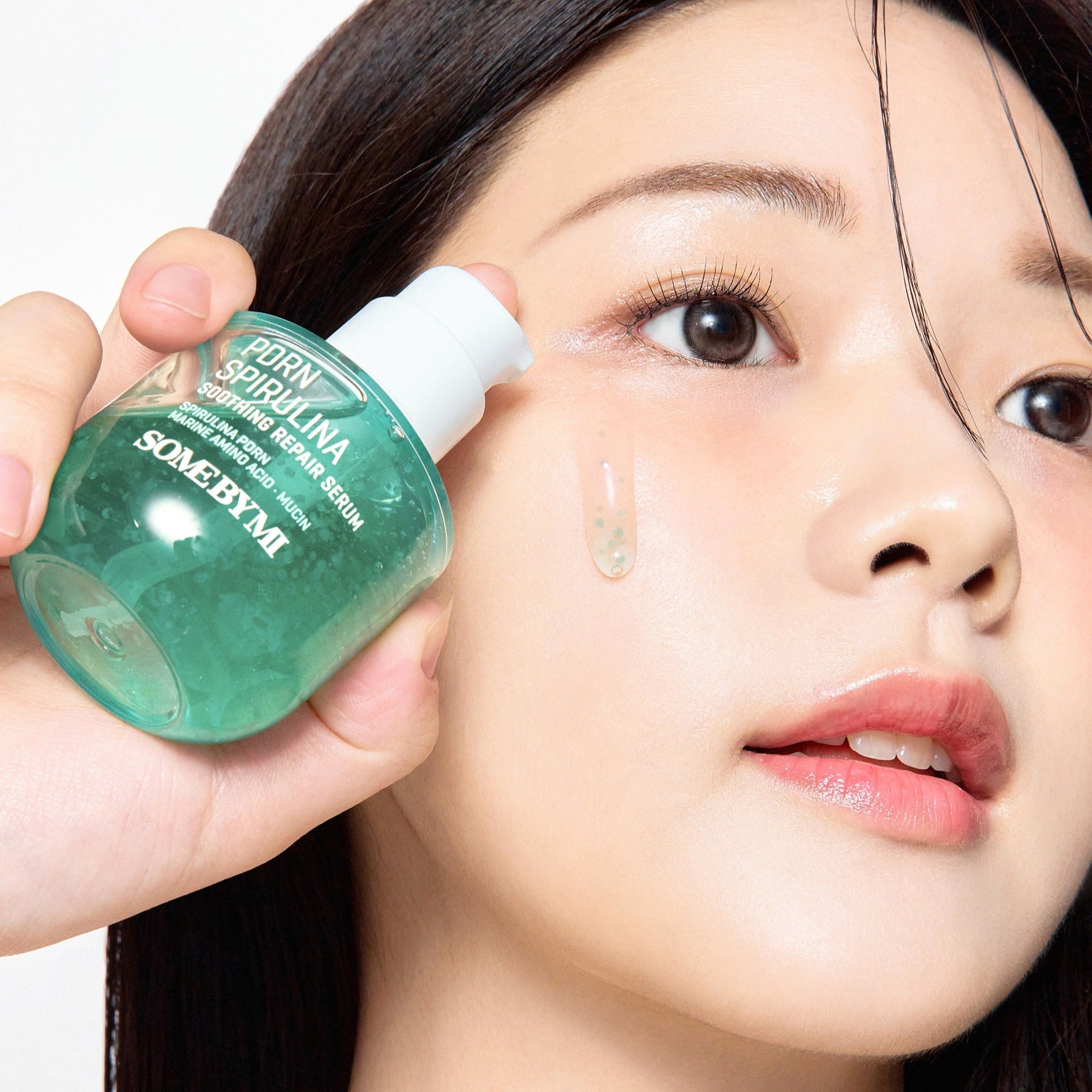 Woman applying SOME BY MI PDRN Spirulina Soothing Repair Serum 50ml to her face for skin repair and soothing