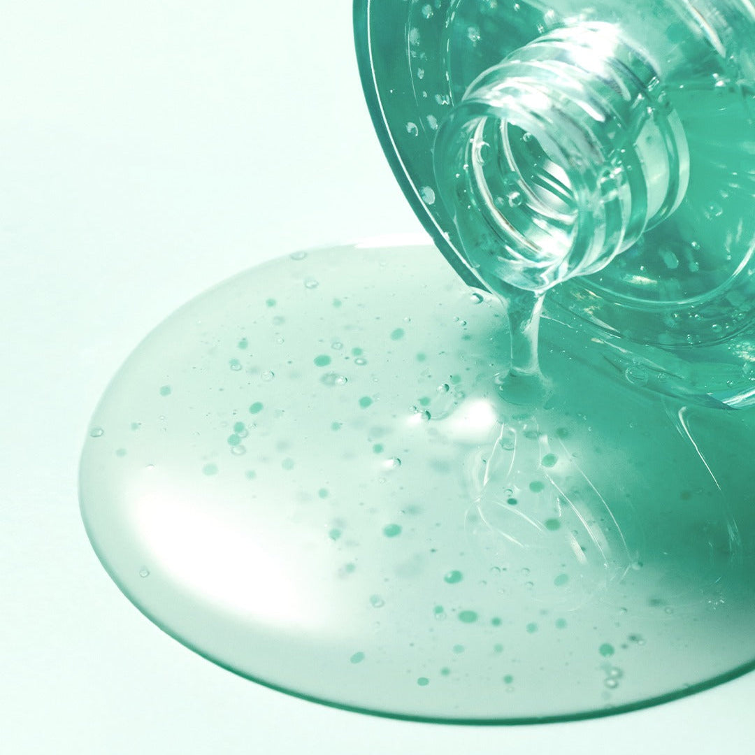 SOME BY MI PDRN Spirulina Soothing Repair Serum 50ml spilling from bottle, showcasing texture and color.