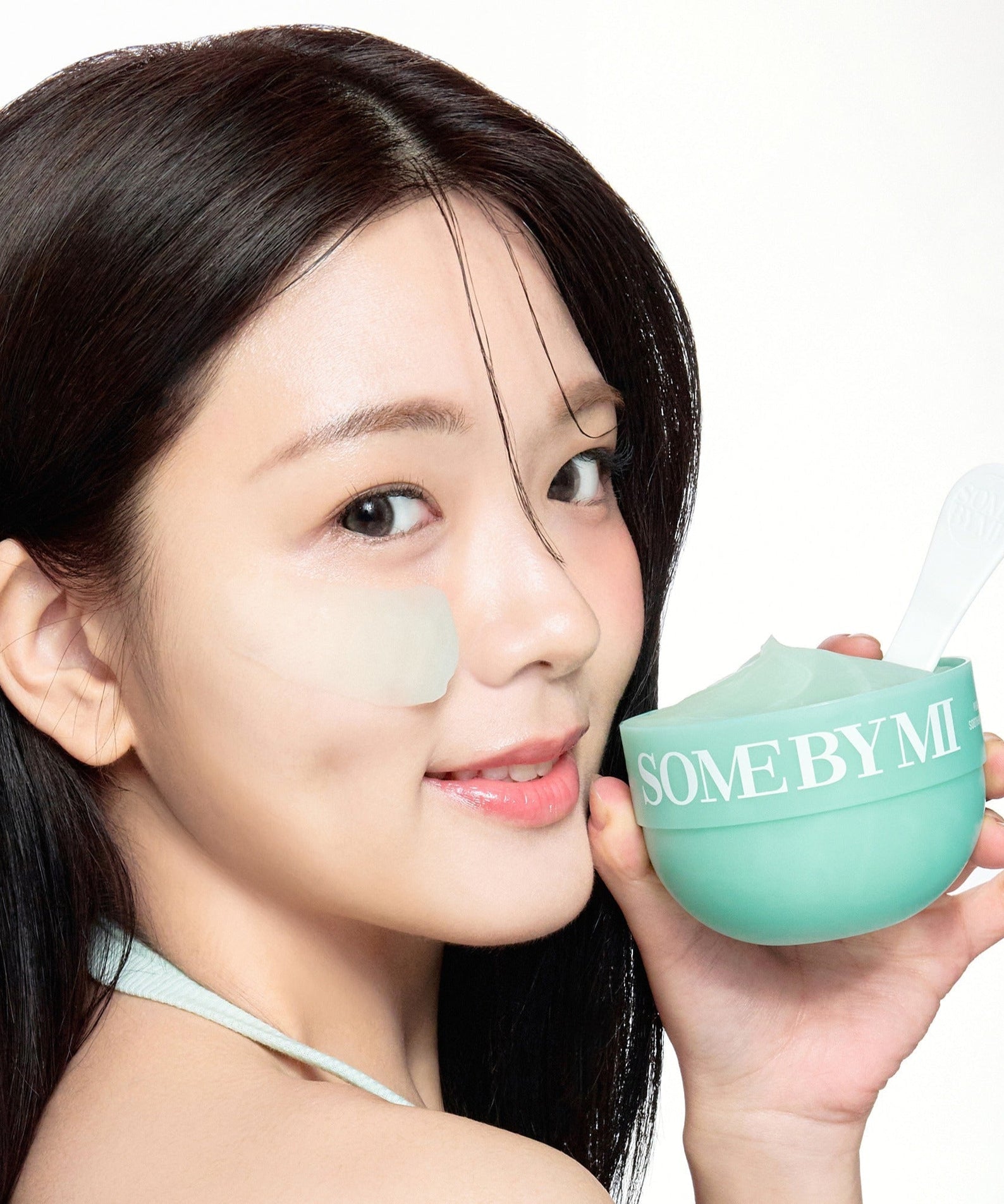 Woman applying SOME BY MI PDRN Spirulina Soothing Sherbet Mask 1g x 10ea from a green container with spatula