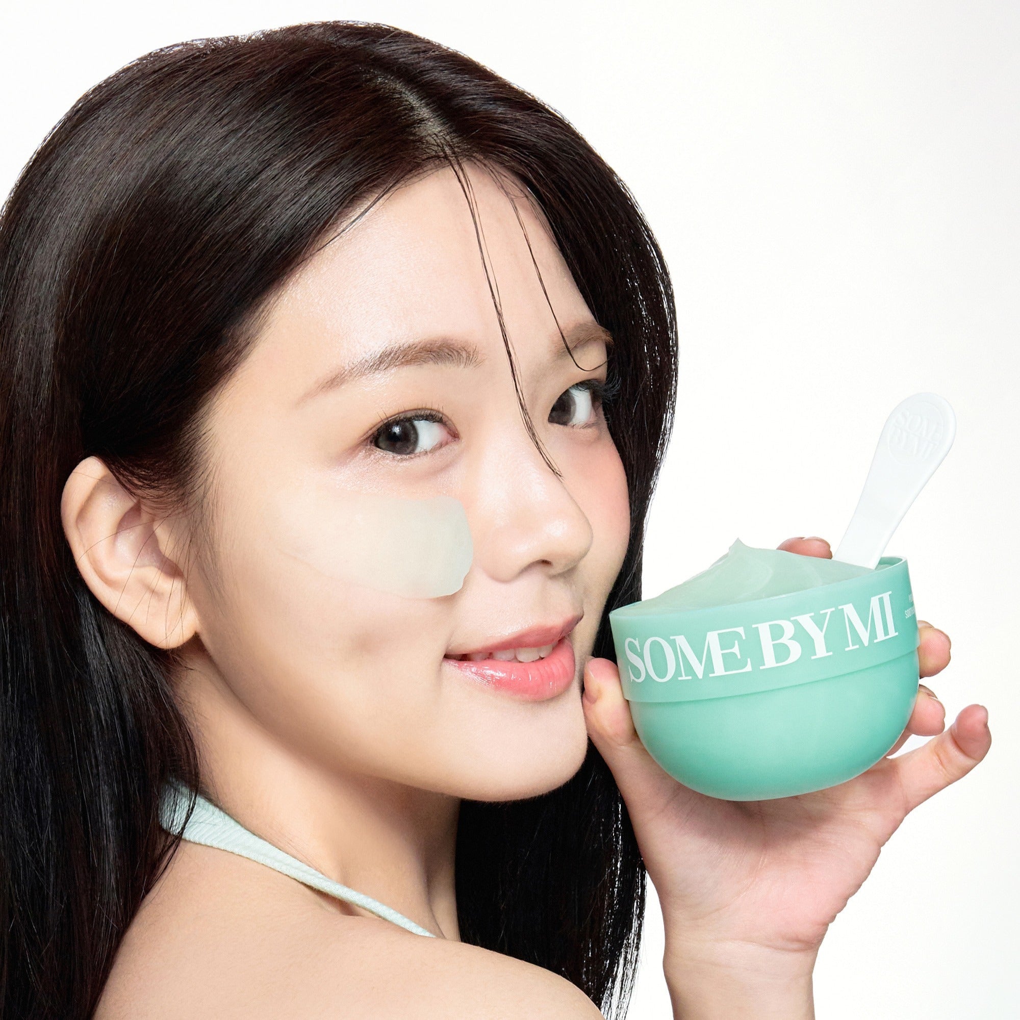 Woman applying SOME BY MI PDRN Spirulina Soothing Sherbet Mask 1g x 10ea from a green container with spatula