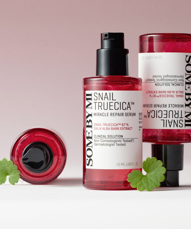 SOME BY MI Snail Truecica Miracle Repair Serum 50ml bottles with green leaves, showcasing skincare product packaging and design.