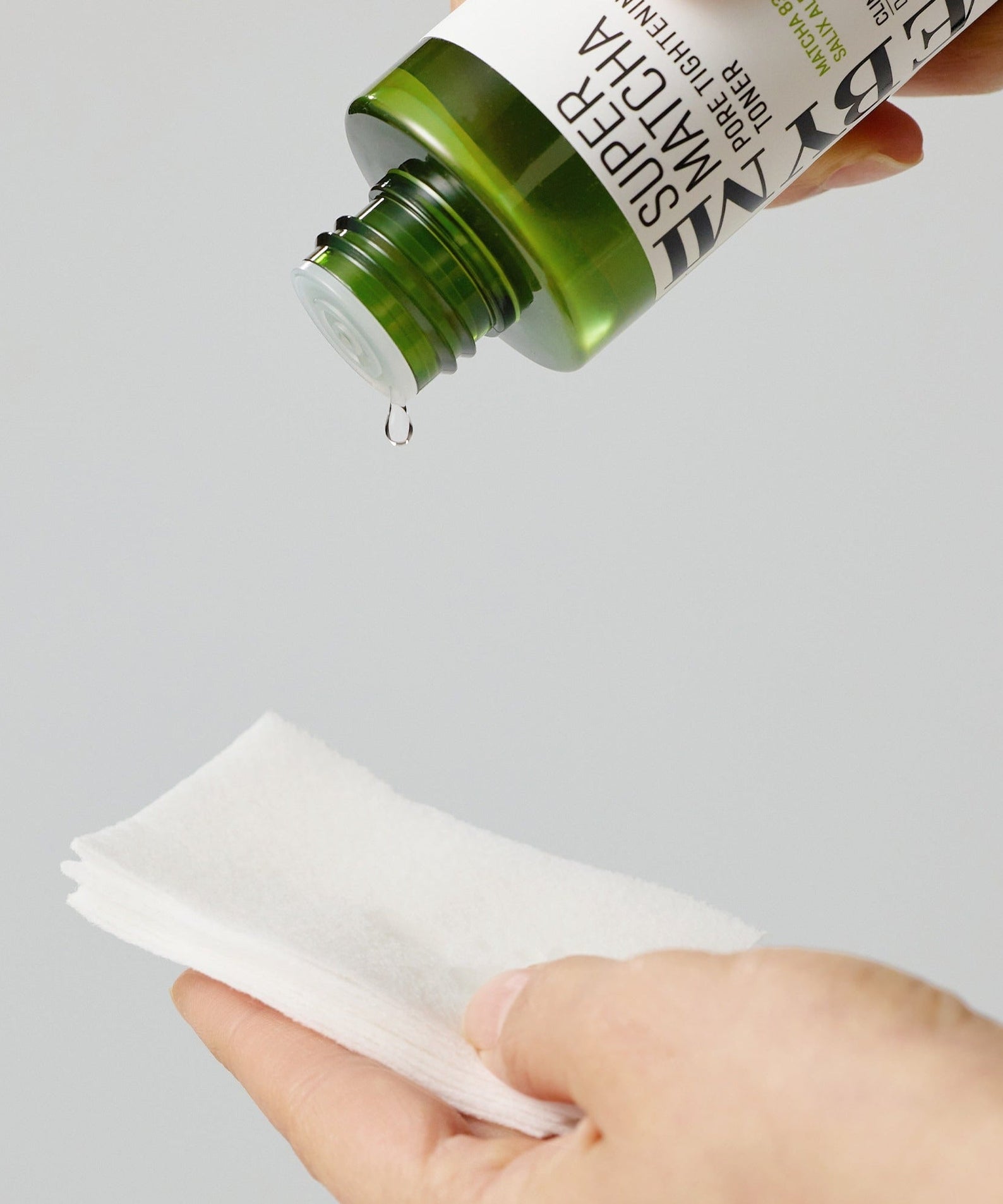 SOME BY MI Super Matcha Pore Tightening Toner 150ml being poured onto cotton pads for skincare routine