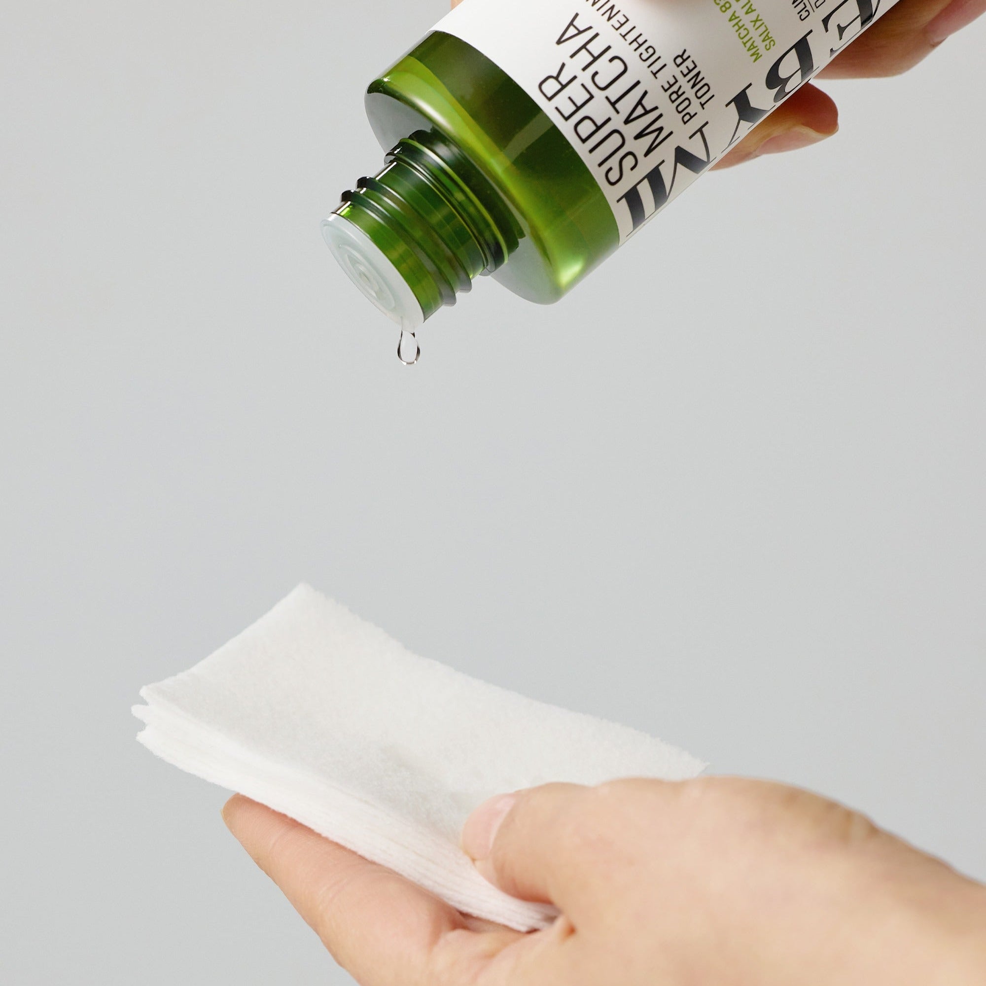 SOME BY MI Super Matcha Pore Tightening Toner 150ml being poured onto cotton pads for skincare routine