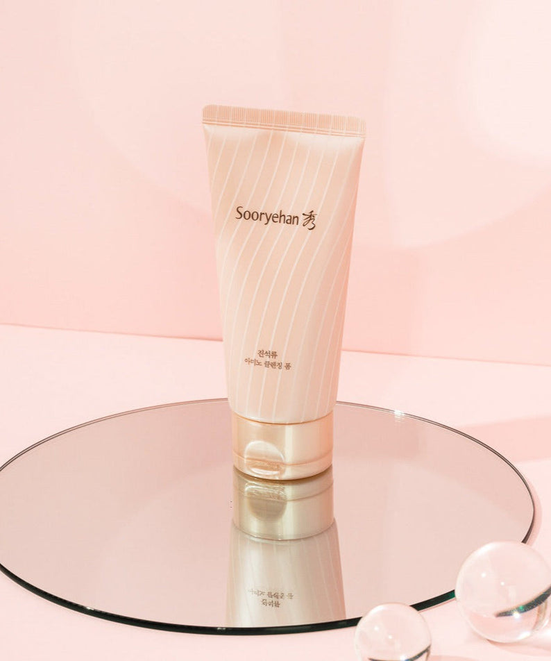 SOORYEHAN Jinseokryu Amino Cleansing Foam 160ml product displayed on a mirror with a soft pink background.