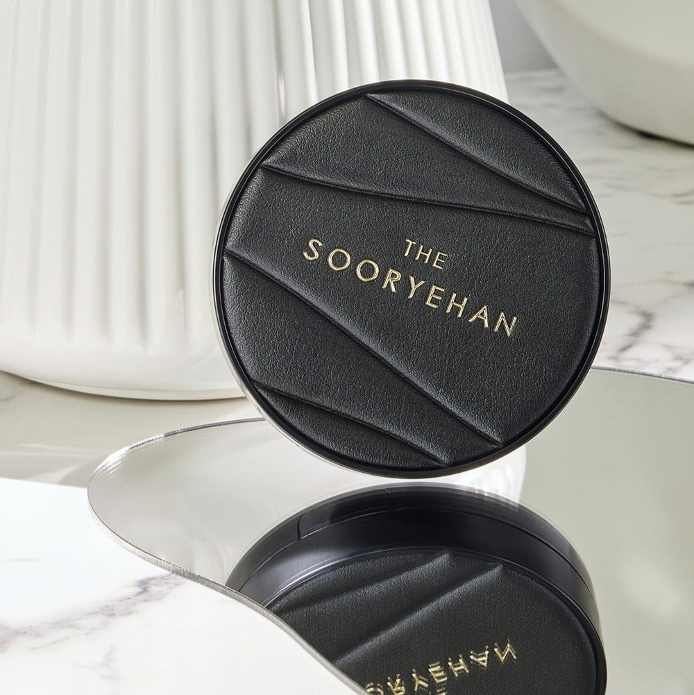 SOORYEHAN The Black Tension Fit Mesh Cushion 13g on a marble surface, reflecting elegance and luxury in design.
