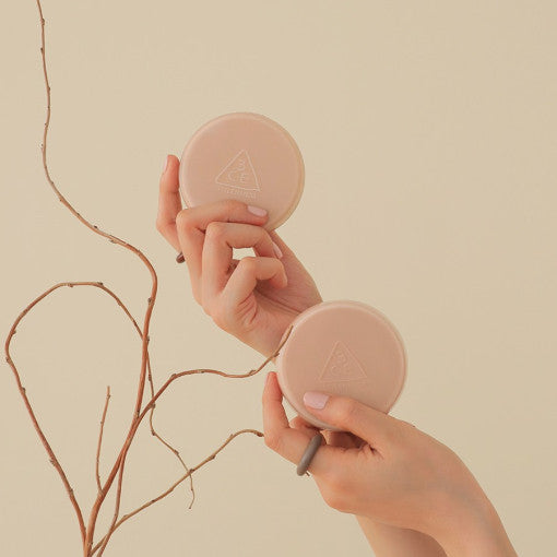 Hands holding STYLE NANDA 3CE Soft Matte Fit Cushion against a neutral background.
