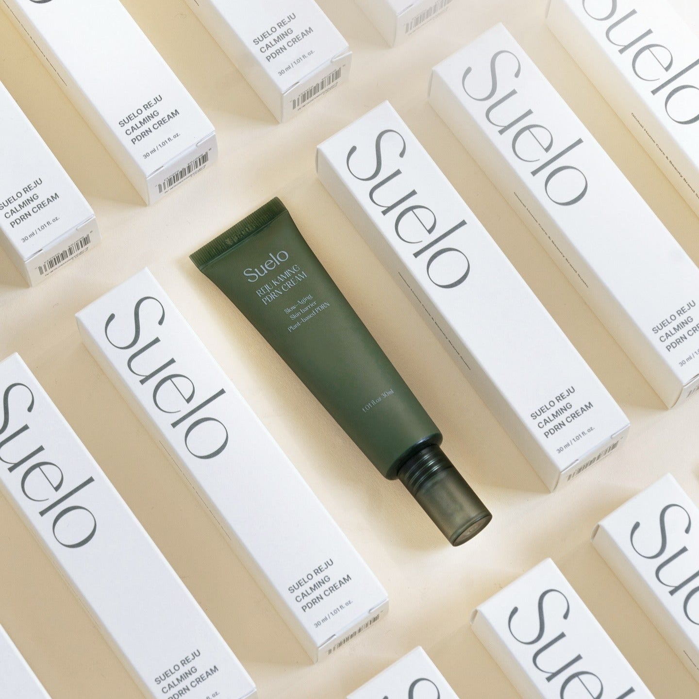 SUELO Reju Calming PDRN Cream 30ml in green tube with packaging boxes arranged around it