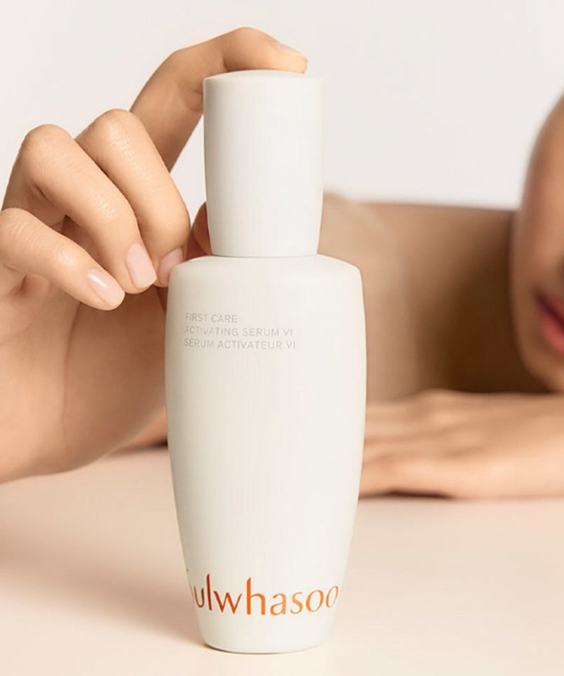 SULWHASOO First Care Activating Serum VI bottle held by person showing skincare packaging