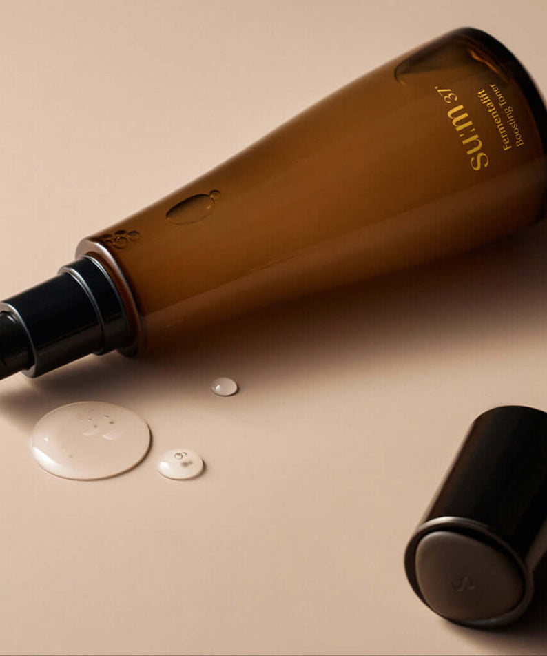 SU:M37 Fermentalift boosting toner 150ml bottle with open cap, showcasing product texture on a beige background