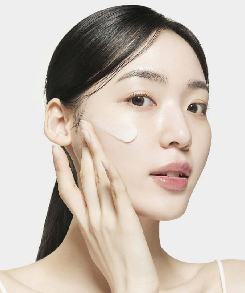 Woman applying SU:M37 Microactive Pink Vitamin Bubble Tox Mask 4ml (14 sheet) on her cheek