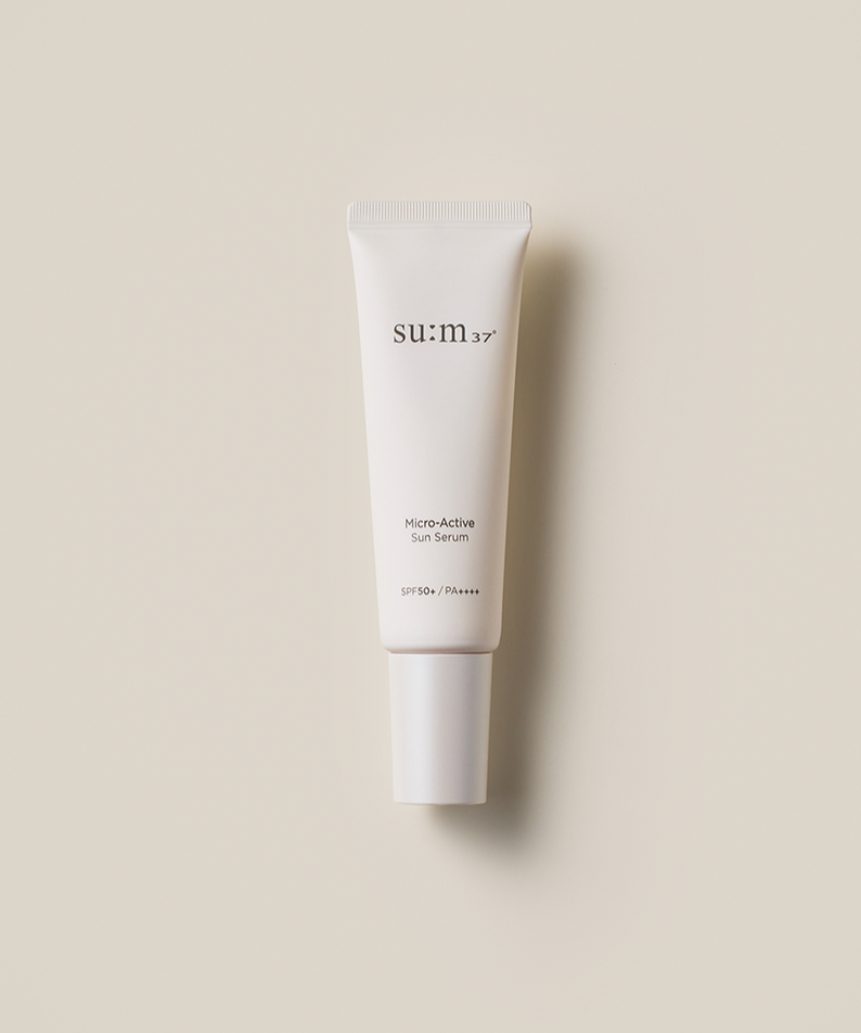 SU:M37 Microactive Sun Serum 50ml in white tube with SPF50+ protection on beige background.