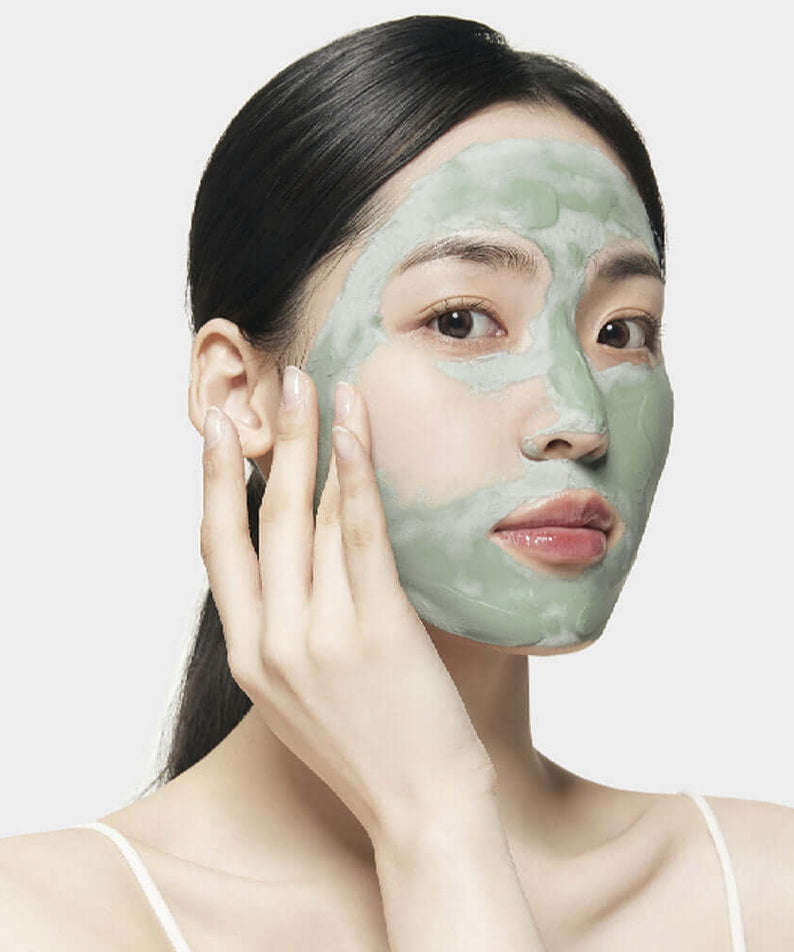 Woman applying SU:M37 Microactive Super Matcha Pore Mask 100ml to face for skincare routine