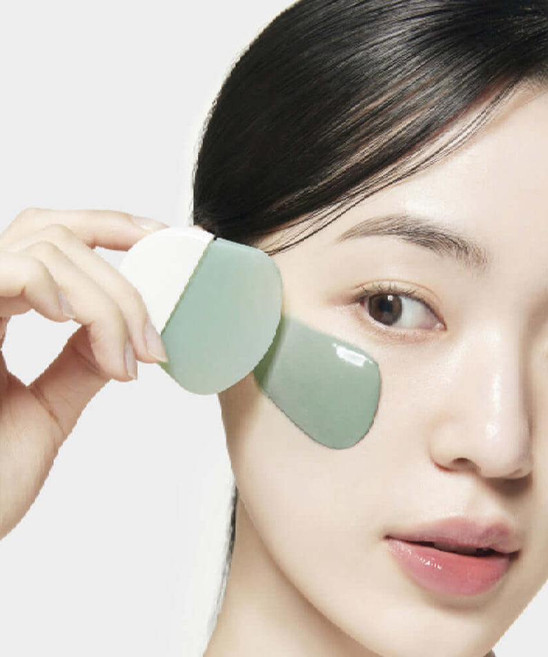 Woman applying SU:M37 Microactive Super Matcha Pore Mask 100ml to her face, demonstrating skincare routine.