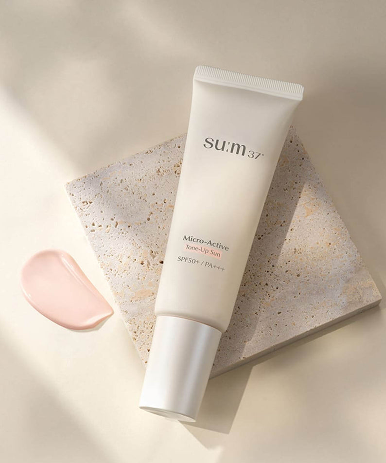 SU:M37 Microactive Tone Up Sun 50 SPF50+ / PA+++ tube on stone background with product swatch