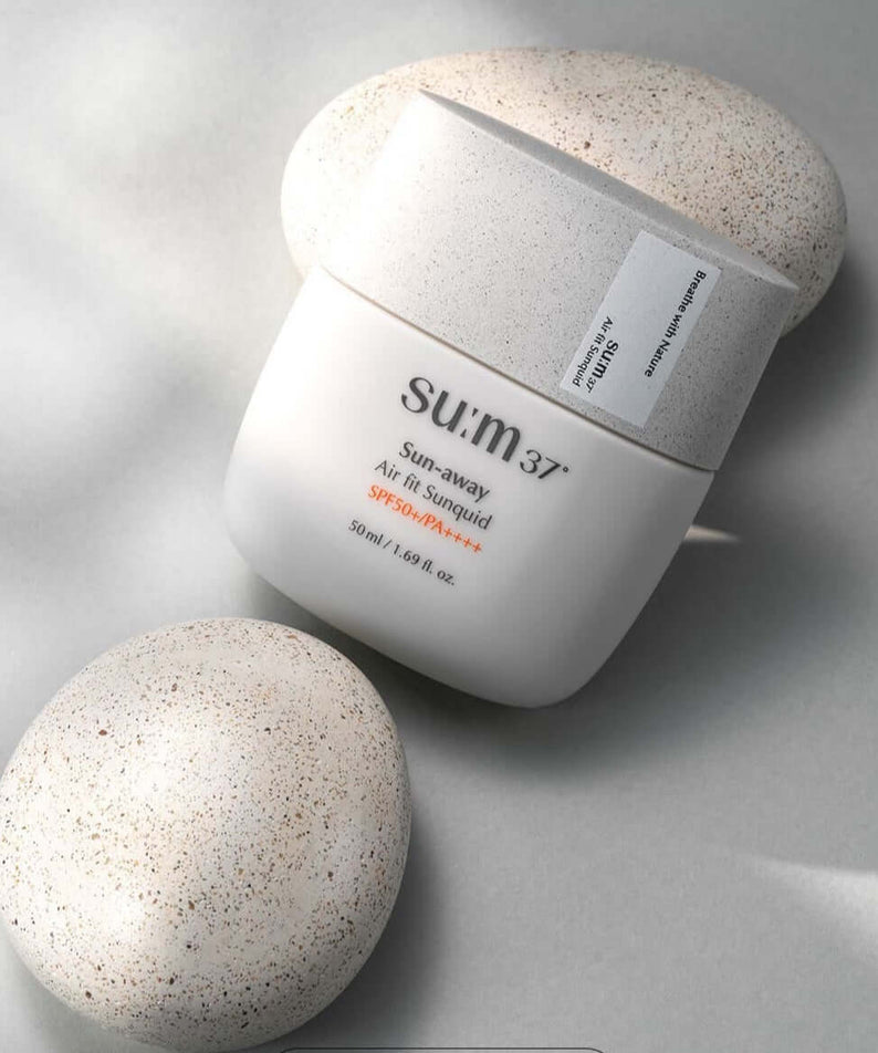 SU:M37 Sun-Away Airfit Sunquid 50+/PA++++ 50ml sun protection product image on a textured background.