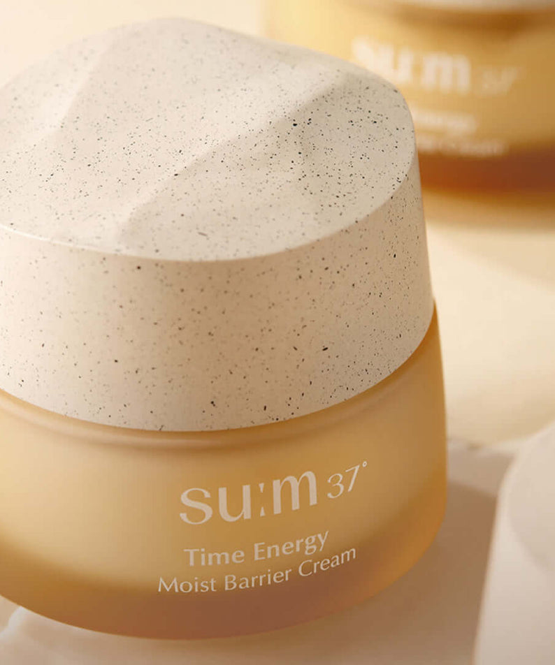 SU:M37 Time Energy Moist Barrier Cream 50ml in a beige jar with a textured lid on display, highlighting the luxurious skincare product.