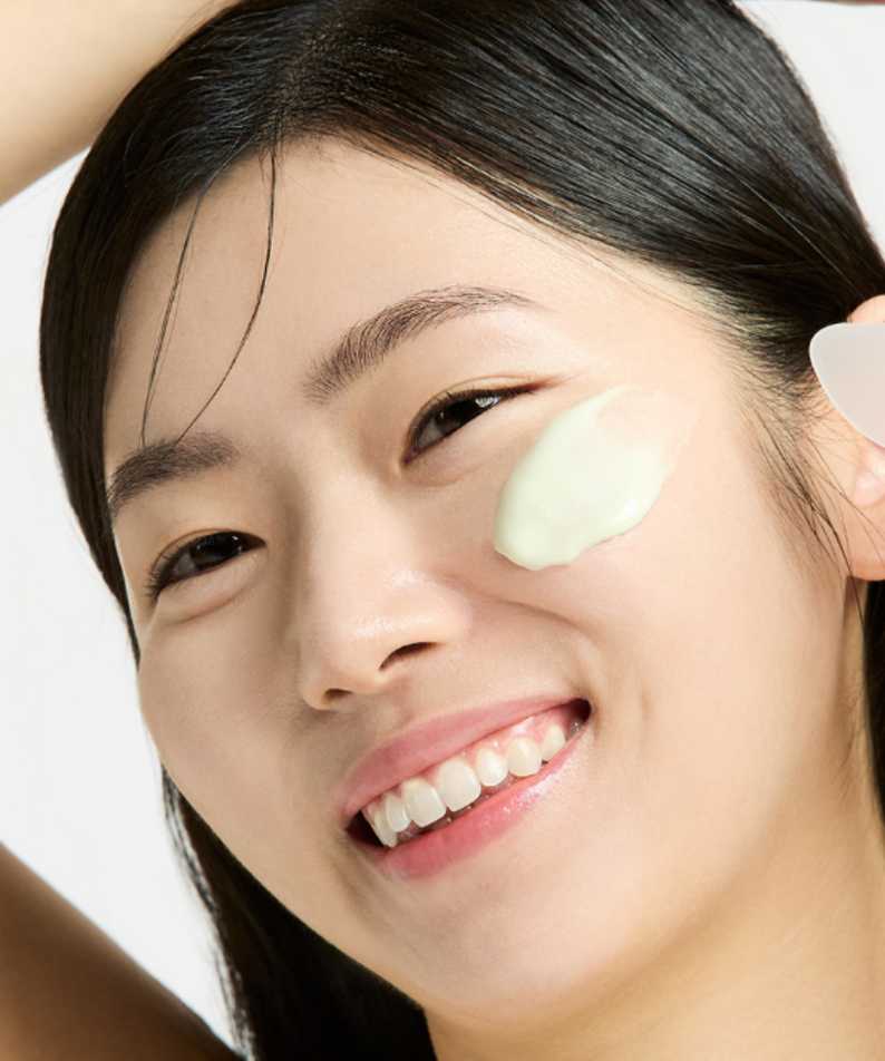 Woman applying SUNGBOON EDITOR Boosting Modeling Pack Green Tomato Pore Tightening to her face for skincare.