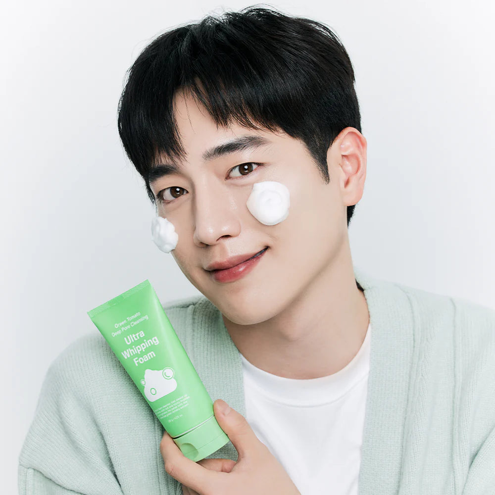 Person holding a tube of SUNGBOON EDITOR Green Tomato Pore Whipping Foam 120g with product applied on their face.