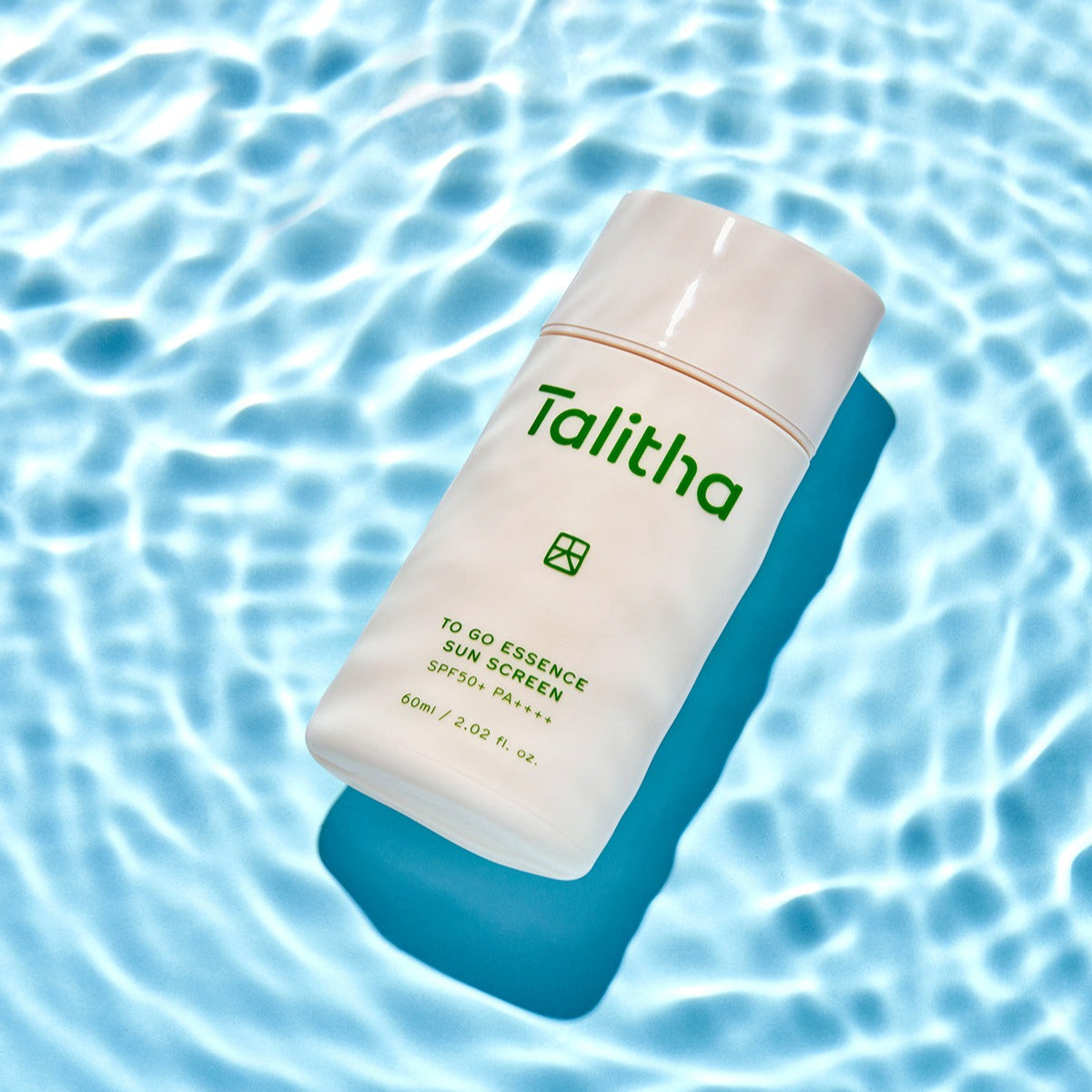 TALITHA KOUM To go Essence Sun Screen 60ml product image over a water pattern background
