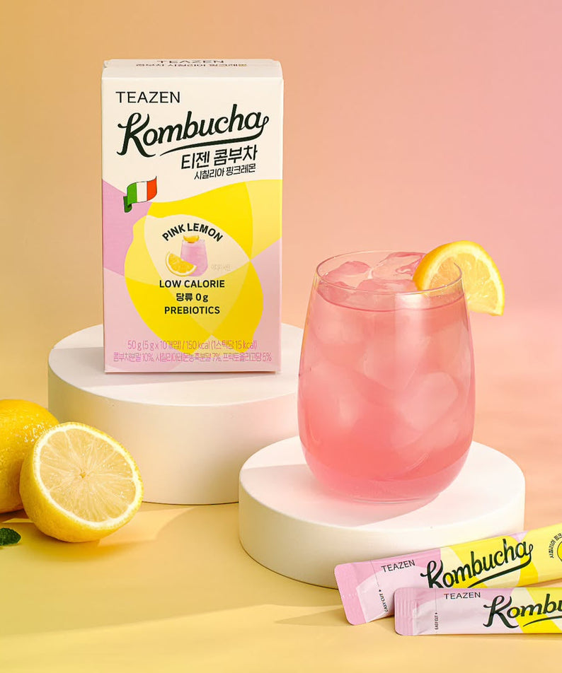 TEAZEN Kombucha Sicillian Pink Lemon 10 Sticks box with two sticks, glass of pink drink with lemon slice, and whole lemon on display.