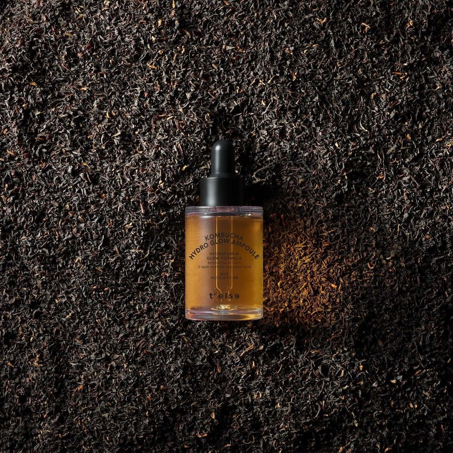 T'ELSE Kombucha Hydro Glow Ampoule 30ml bottle on tea leaves background